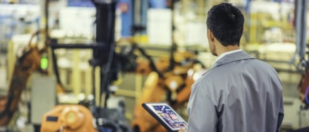 A man in a factory holding a tablet