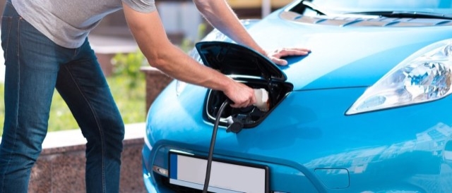 A person charging an electric vehicle